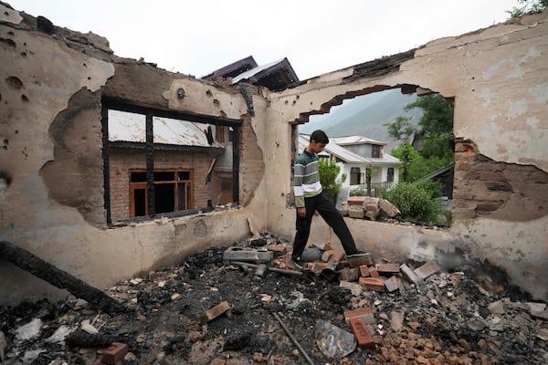 A Kashmiri village boy walks inside a house damaged by Pakistani artillery shelling, at Salamabad village in Uri ,north of Srinagar, Indian controlled Kashmir, Thursday, May 8, 2025. (AP Photo/Mukhtar Khan)
