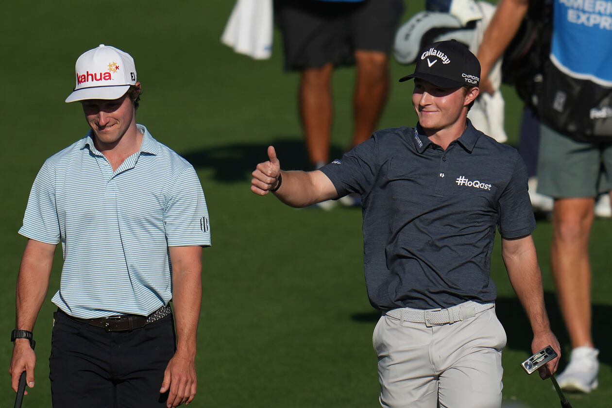 Blades Brown, right, reacts for a cheering gallery as he walks with David Ford as the gallery cheers for Brown who finished with a 12-under-par 60 during the second round of the American Express golf event at the Jack Nicklaus Tournament Course at PGA West Friday, Jan. 23, 2026, in La Quinta, Calif. (AP Photo/Ross D. Franklin)