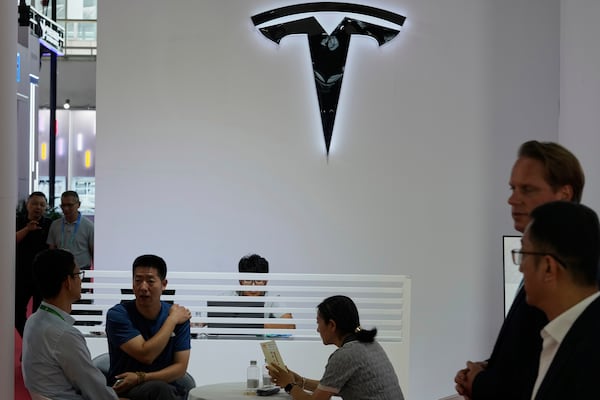 Visitors at the Tesla booth during the 3rd China International Supply Chain Expo at the China International Exhibition Center, in Beijing, China, Friday, July 18, 2025. (AP Photo/Mahesh Kumar A.)