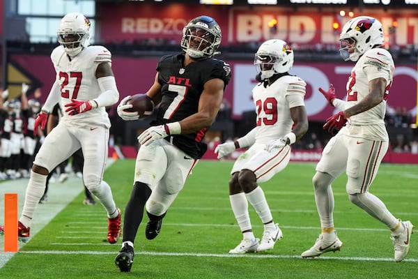 Falcons running back Bijan Robinson (center) scores a touchdown against the Cardinals on Sunday, Dec. 21, 2025, in Glendale, Ariz. The Falcons (6-9) have won consecutive games against struggling teams. (Rick Scuteri/AP)