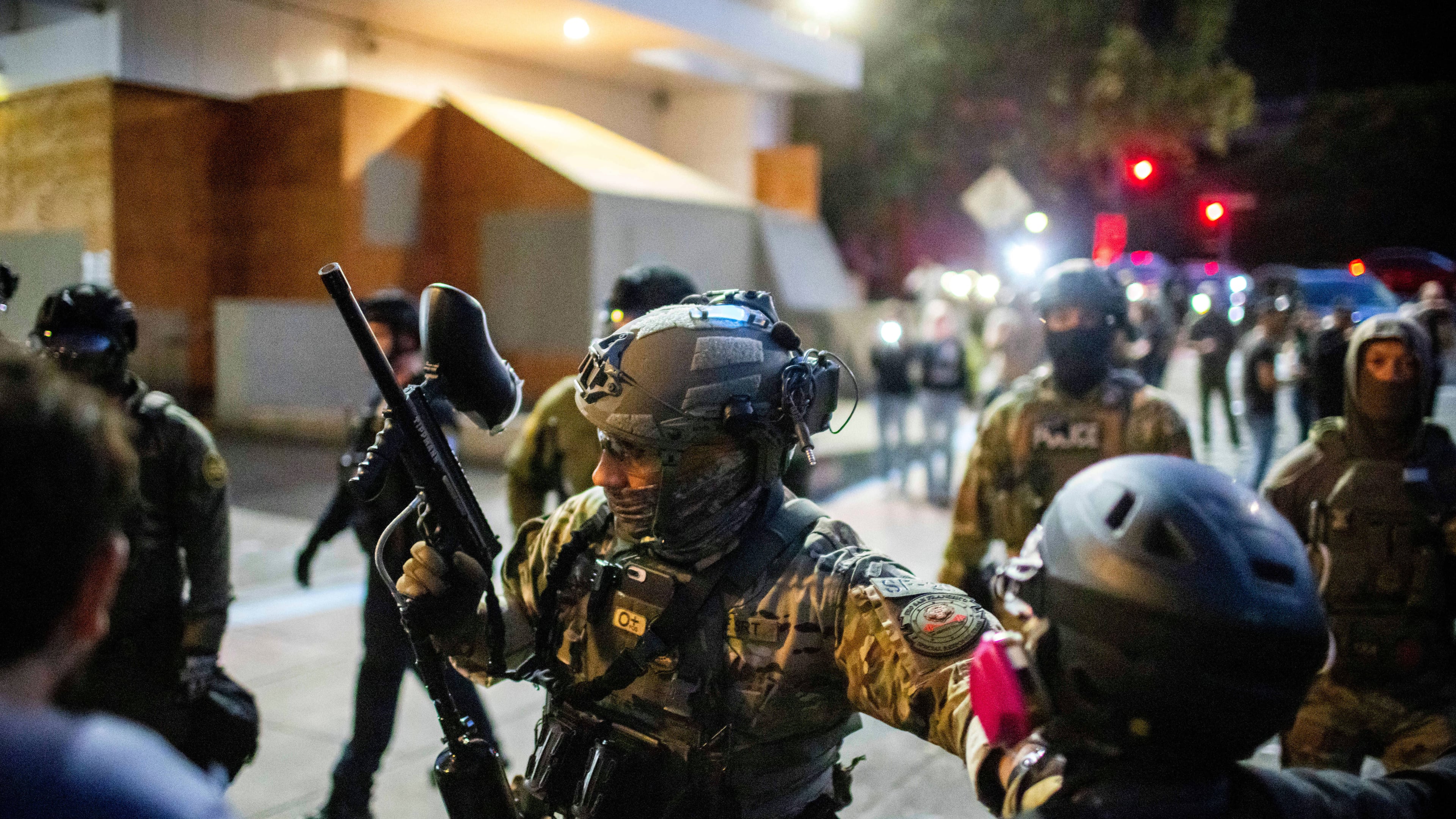 Police and Federal officers stand guard an area by the U.S. Immigration and Customs Enforcement facility in Portland, Ore. on Sunday, October. 5, 2025. (AP Photo/Ethan Swope)