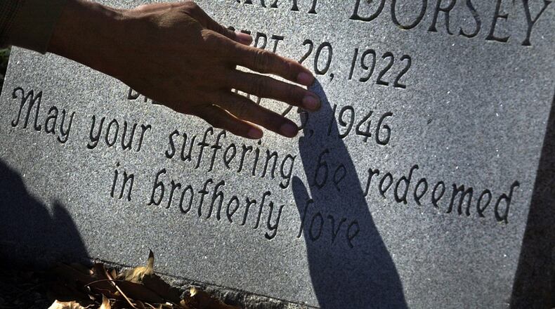 Bobby Howard touches a memorial tombstone for Moore's Ford lynching victim Mae Murray Dorsey during a visit to the Zion Hill Cemetery in Monroe, Ga., on Monday, Feb. 26, 2001.