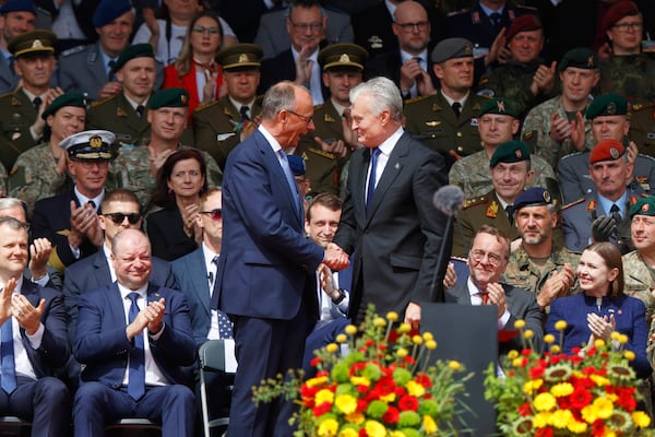 German Chancellor Friedrich Merz, left, shakes hands with Lithuania's President Gitanas Nauseda at a formal inauguration of a German brigade for NATO's eastern flank in Vilnius, Lithuania, Thursday, May 22, 2025. (AP Photo/Mindaugas Kulbis)