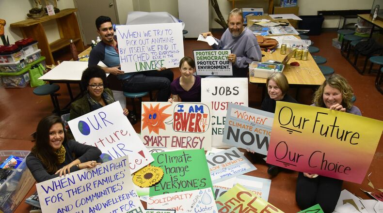 Participants (clockwise from left) Marinangeles Gutierrez, BrionteMcCorkle (assistant director of Georgia Siera Club), Ian Karra, Cecilia Harris, Martin McConaughy, Diane Shearer and Brenda Constan hold signs during a sign-making session for people marching in the Atlanta Social Justice and Women’s March on January 21, at Georgia Sierra Club on Thursday, January 12, 2017. HYOSUB SHIN / HSHIN@AJC.COM