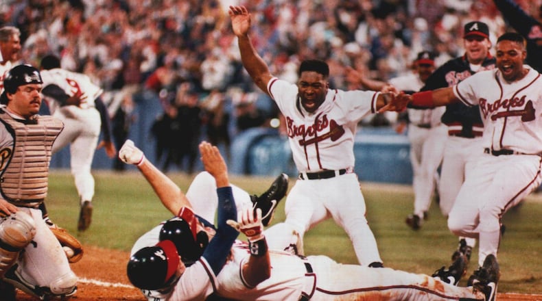 Former Brave Sid Bream, prone on the ground, gets mobbed by teammates David Justice,(on the ground with him), Ron Gant and Brian Hunter, after scoring the winning run in the bottom of the 9th inning of Game 7 of the 1992 NLCS against the Pittsburgh Pirates.