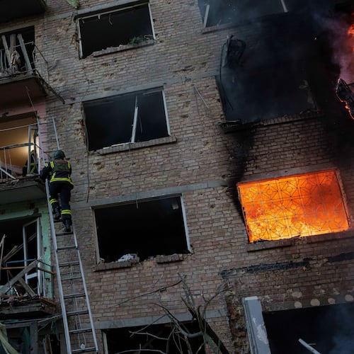 A rescue worker climbs on a ladder to help evacuate people from a residential building being destroyed after a Russian strike on Kyiv, Ukraine, Sunday, May 24, 2026. (AP Photo/Evgeniy Maloletka)