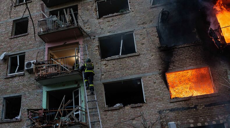 A rescue worker climbs on a ladder to help evacuate people from a residential building being destroyed after a Russian strike on Kyiv, Ukraine, Sunday, May 24, 2026. (AP Photo/Evgeniy Maloletka)