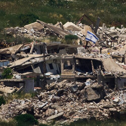 An Israeli flag hangs on a destroyed building in southern Lebanon as seen from northern Israel, Thursday June 4, 2026. (AP Photo/Ariel Schalit)