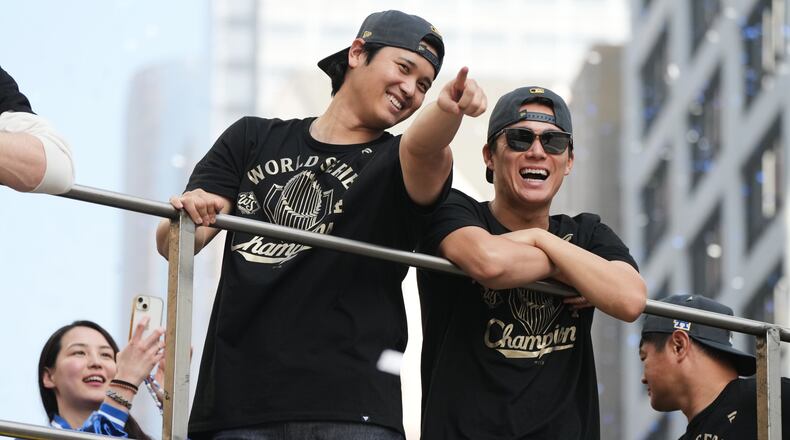 Los Angels Dodgers' Shohei Ohtani, left, and Yoshinobu Yamamoto ride on a double-decker bus during a parade to celebrate the baseball team's World Series win on Monday, Nov. 3, 2025, in Los Angeles. (AP Photo/Jae C. Hong)