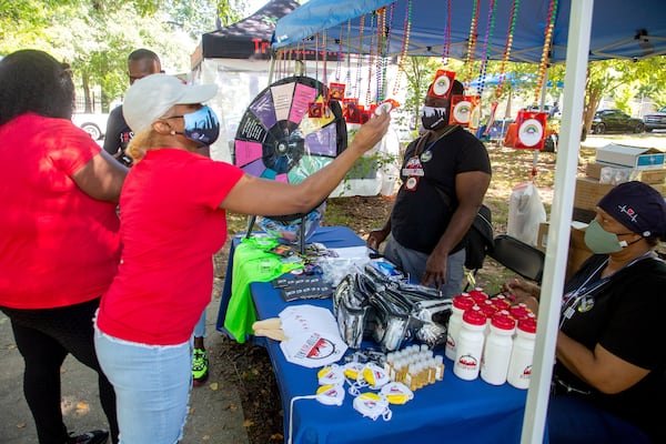 People look over the items on the Fulton County Board of Health tent during the Atlanta Black Pride celebration at Central Park on Saturday, Sept. 4, 2021. (Steve Schaefer for the AJC)