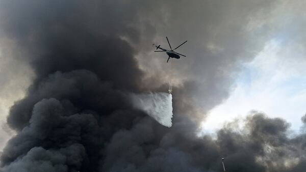 A helicopter drops water on the fire, Sunday, April 27, 2025, after a massive explosion and fire rocked a port near the southern port city of Bandar Abbas, Iran on Saturday. (AP Photo/Meysam Mirzadeh/Tasnim News)