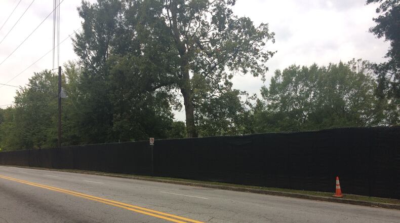 A fence put up for the construction of the Grant Park Gateway parking garage blocks access to part of the sidewalk bordering the park.
