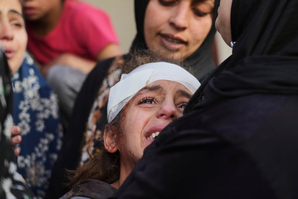 Yamama Jundia, 13, injured in an Israeli airstrike, grieves alongside others over the bodies of their relatives, who were killed in the same strike, at the Baptist Hospital in Gaza City on Thursday, April 3, 2025. (AP Photo/Jehad Alshrafi)