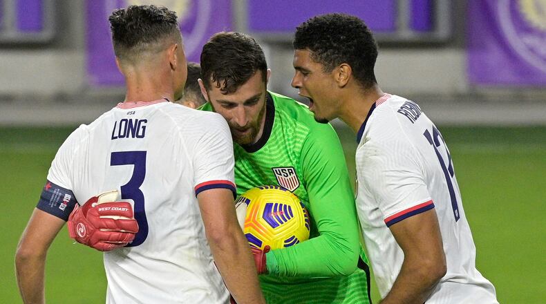 United States goalkeeper Matt Turner (center) is congratulated by defenders Aaron Long (3) and Miles Robinson (12) after stopping a penalty kick by Trinidad and Tobago defender Alvin Jones during the second half of an international friendly soccer match, Sunday, Jan. 31, 2021, in Orlando, Fla. (Phelan M. Ebenhack/AP)