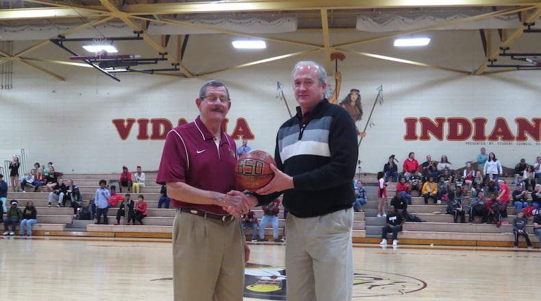 Vidalia Lady Indians coach Chunk Reid, left, and Vidalia principal John Sharpe shake hands at mid-court on Tuesday, Jan. 19, 2016 during halftime of the Lady Indians' basketball game against Bacon County. Reid was being honored for his 850th career win as Vidalia's girls basketball coach. (Special to AJC.com)