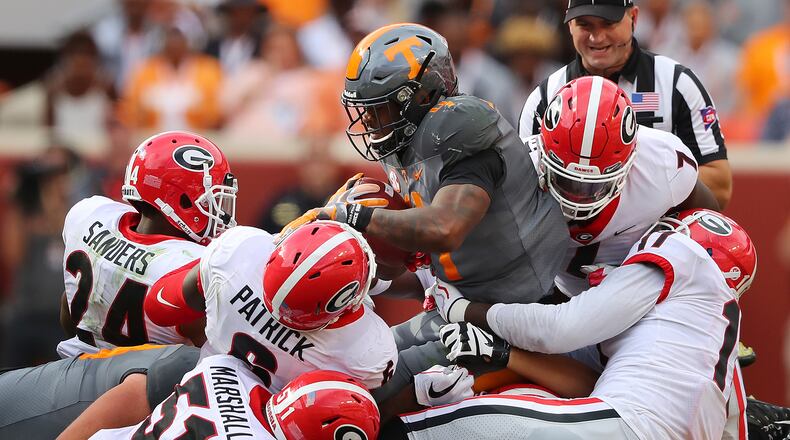 Georgia defenders David Marshall (51), Natrez Patrick (6), Dominick Sanders (24), Lorenzo Carter (7) and Davin Bellamy (17) gang tackle Tennessee running back John Kelly at the line of scrimmage for no gain during the first half of an NCAA college football game against Tennessee on Saturday, Sept. 30, 2017, in Knoxville, Tenn. (Curtis Compton/ccompton@ajc.com)