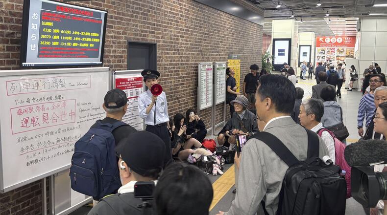 A station clerk of the East Japan Railway Co., provides an update about train services which were suspended due to an earthquake at JR Morioka station in Morioka, northern Japan, Thursday, July 25, 2026. (Kyodo News via AP)