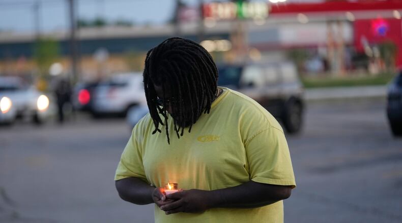 A man holds a candle during a prayer vigil for the victims of a mass shooting earlier in the day, Sunday, April 19, 2026, in Shreveport, La. (AP Photo/Gerald Herbert)