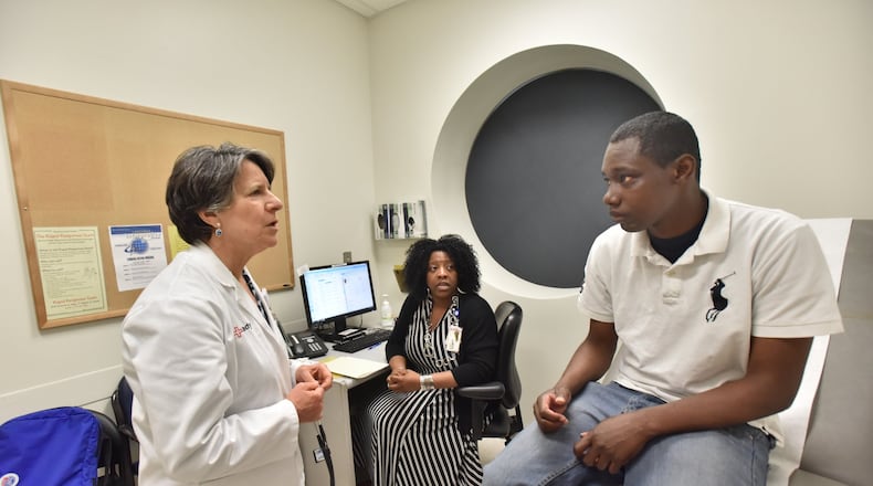 Dr. Claudia Vellozzi, left, and Karen Sutton talk to Alex Harris, a participant in the Chronic Care Clinic program at Grady Memorial Hospital in Atlanta. Vellozzi is the medical director of the clinic that gets doctors, nurses, assistants, pharmacists and community health workers deeply involved in a patient’s situation to reduce visits to the emergency room. Sutton is a licensed clinical social worker in the program. HYOSUB SHIN / HSHIN@AJC.COM