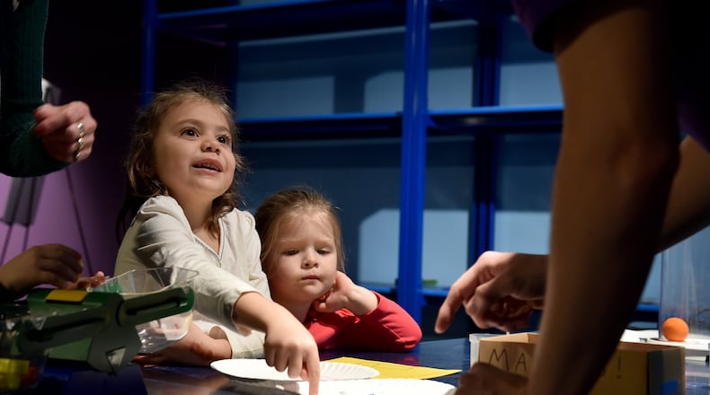 Sophia Lamb, 5, and her friend Ruby Lawes, 3, watch as Gregg Van Laningham conducts a science experiment in the STEM area of the newly designed Children’s Museum of Atlanta. The museum officially reopens Saturday, Dec. 12, after completely revamping the space. BRANT SANDERLIN/BSANDERLIN@AJC.COM