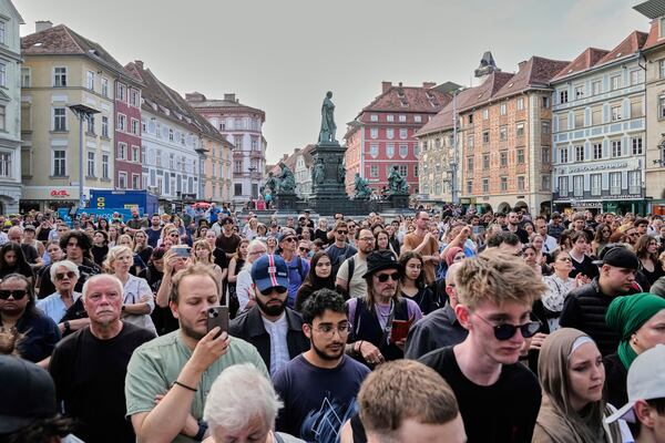 People attend a wreath laying ceremony after a former student opened fire the day before fatally wounding several people and injuring many others before taking his own life, Graz, Austria, Wednesday, June 11, 2025. (AP Photo/Darko Bandic)