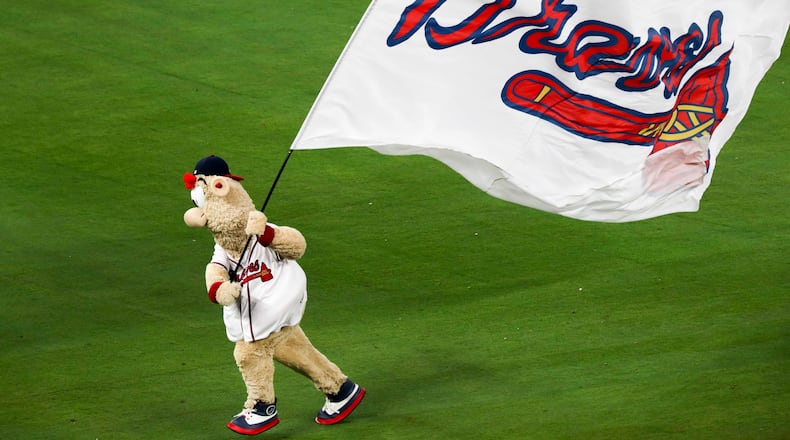 Braves mascot Blooper runs the team flag across the field. ALYSSA POINTER/ALYSSA.POINTER@AJC.COM