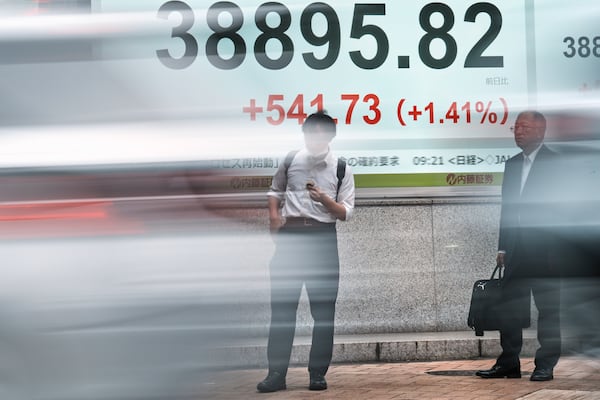 People stand in front of an electronic stock board showing Japan's Nikkei index at a securities firm Tuesday, June 24, 2025, in Tokyo. (AP Photo/Eugene Hoshiko)