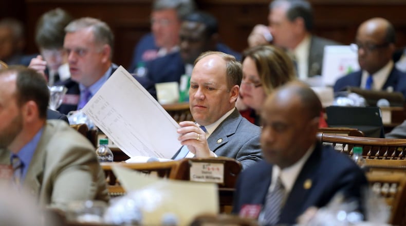 State Rep. Dan Gasaway, R-Homer, flips through the budget as the House listens to a presentation in March 2013. JASON GETZ / JGETZ@AJC.COM