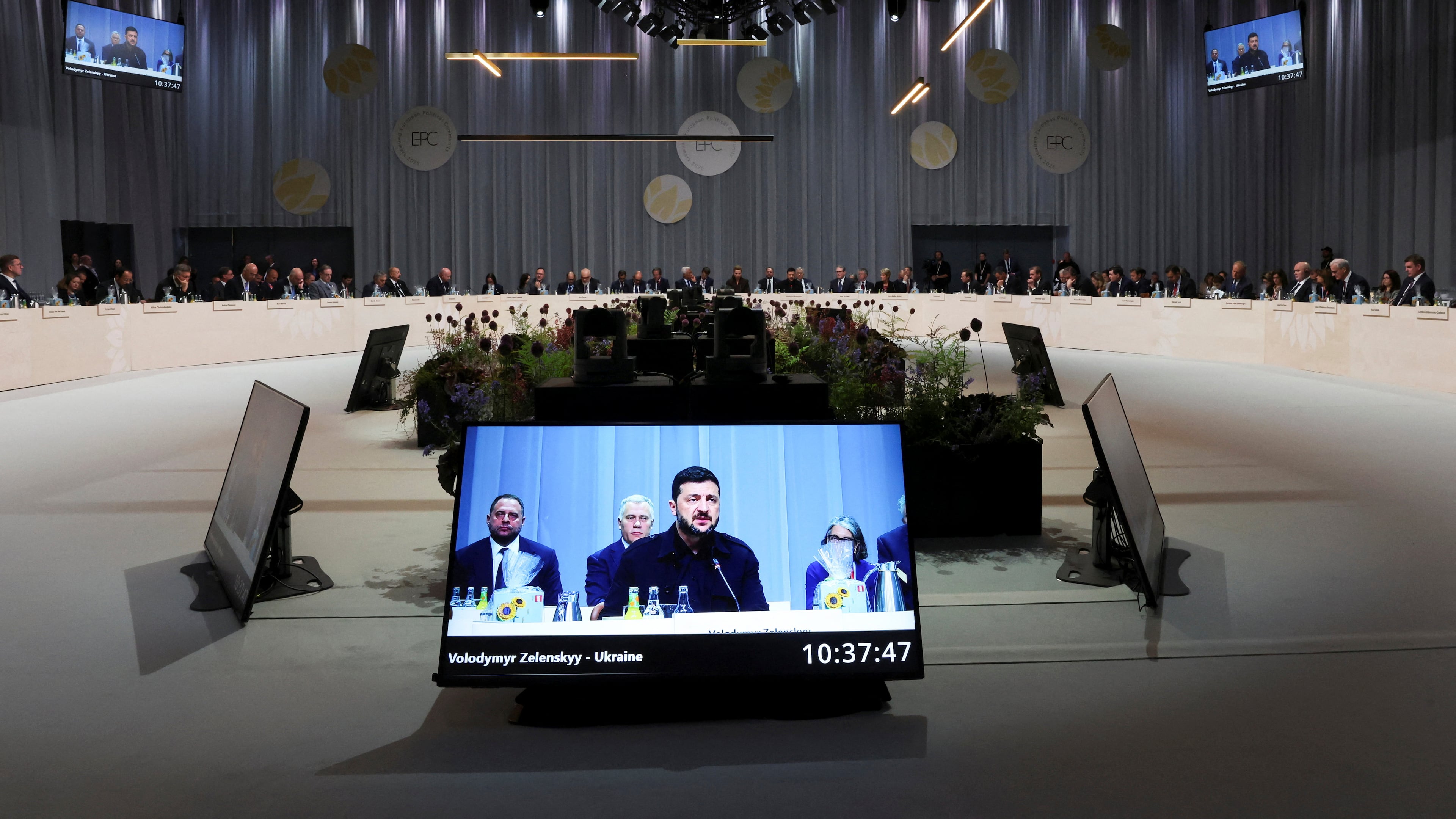 Ukrainian President Volodymyr Zelenskyy is seen on a giant screen as he speaks during the European Political Community summit, in Copenhagen, Thursday, Oct. 2, 2025. (Suzanne Plunkett/Pool Photo via AP)