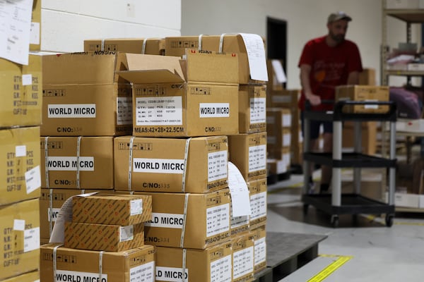 A World Micro employee works in the company's warehouse. (Jason Getz/AJC)