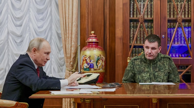 Russian President Vladimir Putin, left, holds a call with military leaders on the Ukraine battlefield situation together with Denis Pirogov, right, a Russian army brigade commander, at the Kremlin in Moscow, on Thursday, Dec. 11, 2025. (Gavriil Grigorov, Sputnik, Kremlin Pool Photo via AP)
