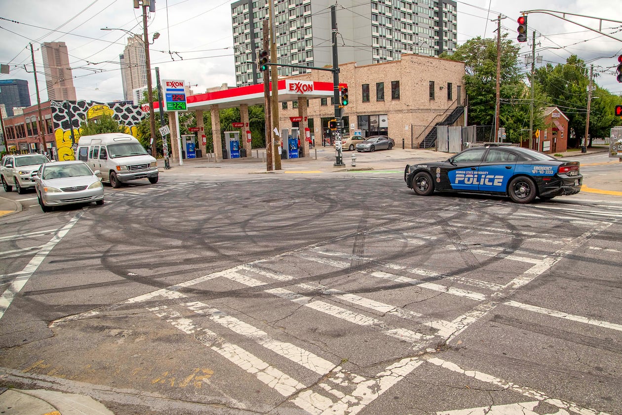 A Georgia State University patrol car rolls through the intersection of Edgewood Avenue SE and Jackson Street SE, where tire doughnuts can be seen after the Fourth of July weekend in Atlanta's Sweet Auburn District. (Alyssa Pointer/AJC 2020)