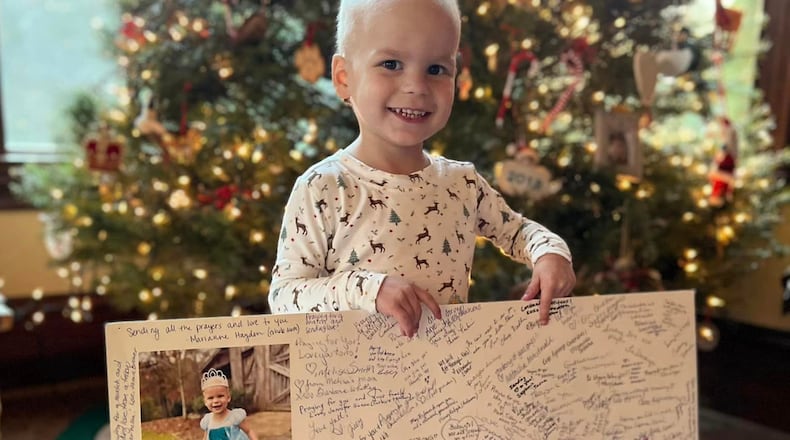 Elena Howard, 3, holds a poster with signatures from hundreds of people who donated blood to help her fight leukemia.
Contributed by: Haley Howard