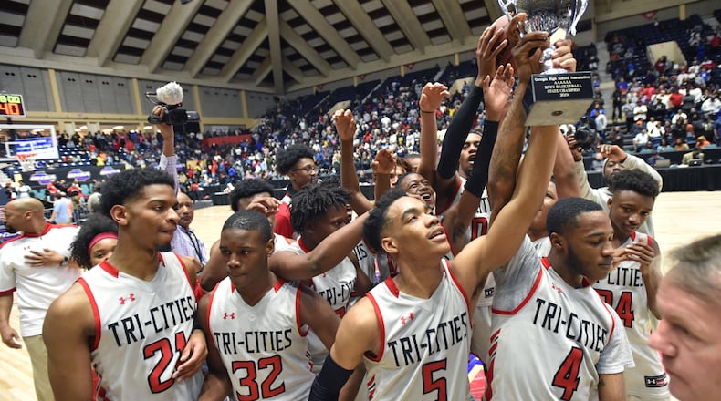 Tri-Cities DeMarcus Johnson (5) helps hoist the Class AAAAAA championship trophy March 9, 2019, at the Macon Centreplex in Macon. Tri-Cities defeated Tuker, 46-43, for the state title.