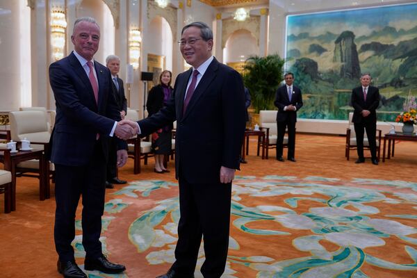 Chinese Premier Li Qiang, right, greets Boeing Global Senior VP Brendan Nelson from a delegation led by U.S. Senator Steve Daines before a meeting held in the Fujian Room at the Great Hall of the People in Beijing, China, Sunday, March 23, 2025. (AP Photo/Ng Han Guan, Pool)