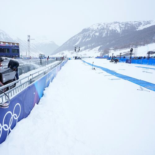 A worker blows snow off a path at the 2026 Winter Olympics, in Livigno, Italy, Wednesday, Feb. 4, 2026. (AP Photo/Gregory Bull)