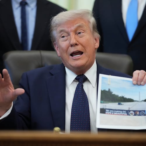 President Donald Trump holds a picture of the Lincoln Memorial Reflecting Pool during an event on health care affordability in the Oval Office at the White House, Thursday, April 23, 2026, in Washington. (AP Photo/Mark Schiefelbein)
