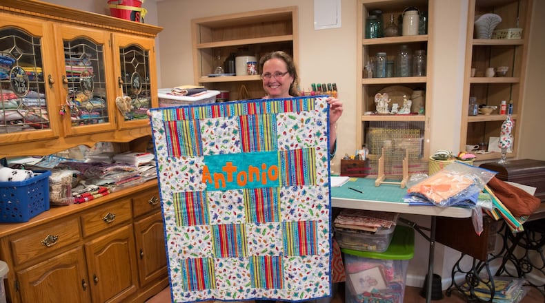 Mary Stevens holds a quilt she made for a child being treated at the Aflac Cancer Center at Children’s Healthcare of Atlanta at Scottish Rite. Stevens, shown at her Canton home, began making quilts for other children at Scottish Rite when her son Michael Stevens was diagnosed with acute lymphoblastic leukemia when he was 4 years old in 1996. It’s estimated she has made as many as 1,000 of the colorful, comforting handmade blankets. BRANDEN CAMP / SPECIAL