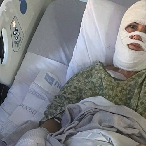 In this photo provided by Connor Milam, her friend Ashley Wasielewski sits with bandages in a hospital bed in Augusta, Ga., on Thursday, Dec. 11, 2025, after witnesses she suffered severe burns when an unknown attacker poured a corrosive chemical over her head at a public park in Savannah. (Connor Milam via AP)