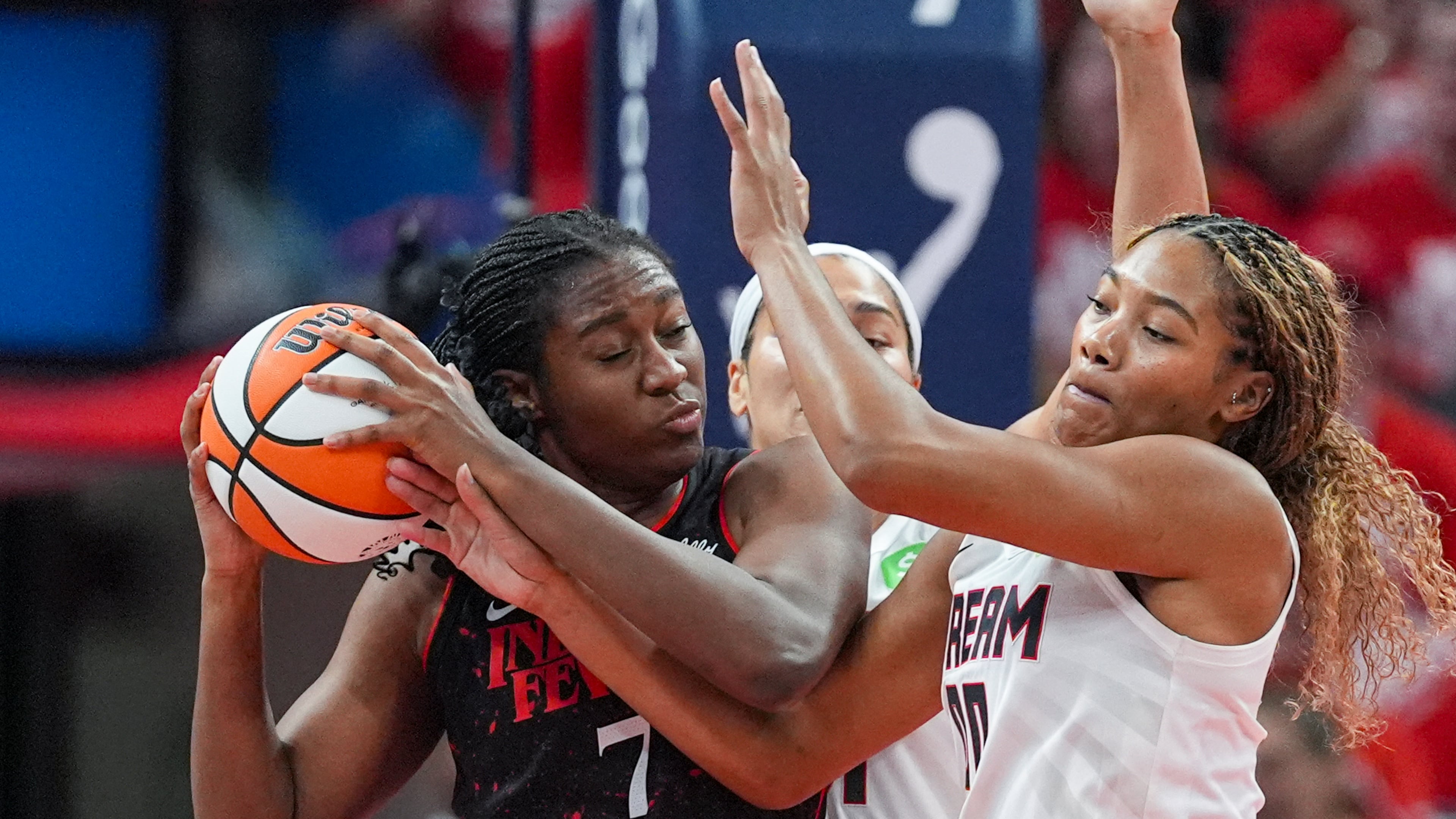 Indiana Fever forward Aliyah Boston (7) get tied up with Atlanta Dream forward Naz Hillmon (0) in the first half of a WNBA basketball playoff game in Indianapolis, Tuesday, Sept. 16, 2025. (AP Photo/Michael Conroy)