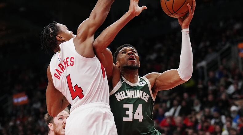Milwaukee Bucks' Giannis Antetokounmpo (34) drives at Toronto Raptors' Scottie Barnes (4) during second half NBA basketball action in Toronto on Tuesday, Nov. 4, 2025. (Nathan Denette/The Canadian Press via AP)