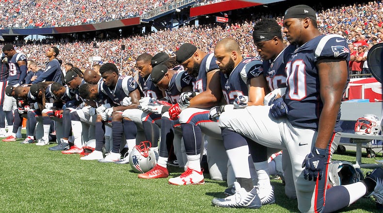 Members of the New England Patriots kneel during the National Anthem before a game against the Houston Texans (Photo by Jim Rogash/Getty Images)