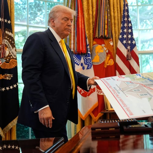 FILE - President Donald Trump holds a chart as he discusses the economy in the Oval Office of the White House, Aug. 7, 2025, in Washington. (AP Photo/Mark Schiefelbein, File)