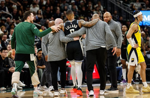 Milwaukee Bucks' Damian Lillard is helped from the floor against the Indiana Pacers during the first half of Game 4 of a first-round NBA basketball playoff series Sunday, April 27, 2025, in Milwaukee. (AP Photo/Jeffrey Phelps)