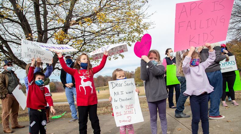 Parents and their children line along 10th Street N.E. near Piedmont Park on  Sunday, December 6, 2020, during a rally calling for the safe, immediate opening of all Atlanta and DeKalb County schools. (Photo: Steve Schaefer for The Atlanta Journal-Constitution)