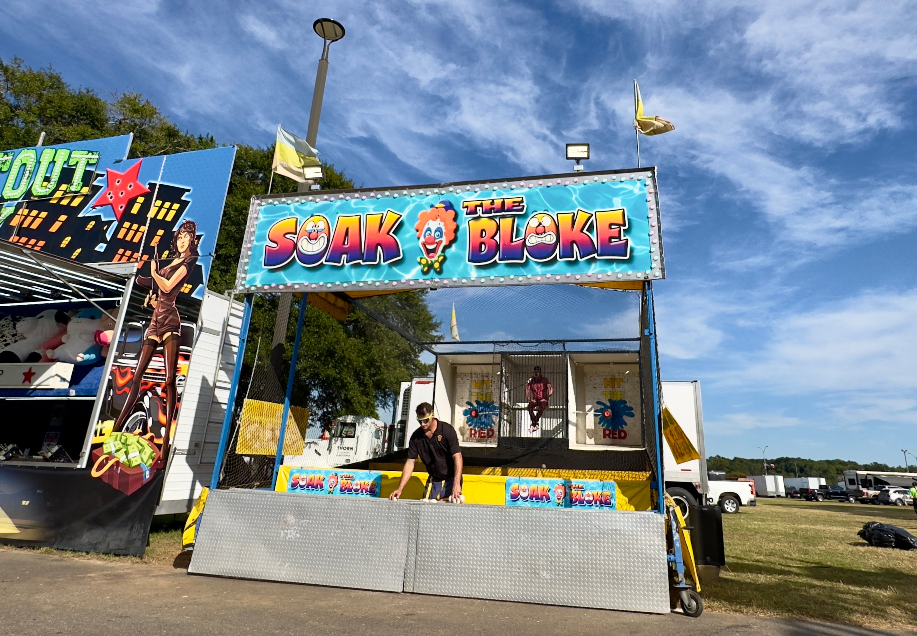 At the Georgia State Fair's Soak the Bloke booth — a dunk-tank clown and cut-down show — patrons do their best to fire baseballs, hit a target and dunk the wisecracking clown. (Joe Kovac Jr./AJC)