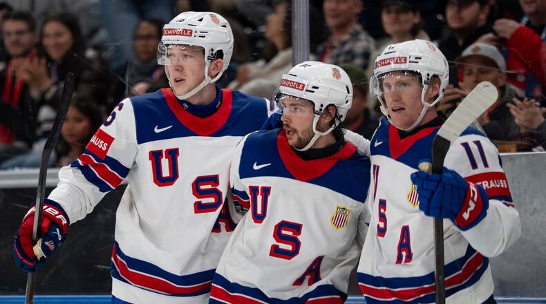 From left, USA's Mason Lohrei, Isaac Howard and Oliver Moore celebrate after their team's second goal, during the 2026 IIHF Men's Ice Hockey World Championship preliminary round group A game between Britain and the United States, in Zurich, Switzerland, Sunday, May 17, 2026. (Claudio Thoma/Keystone via AP)