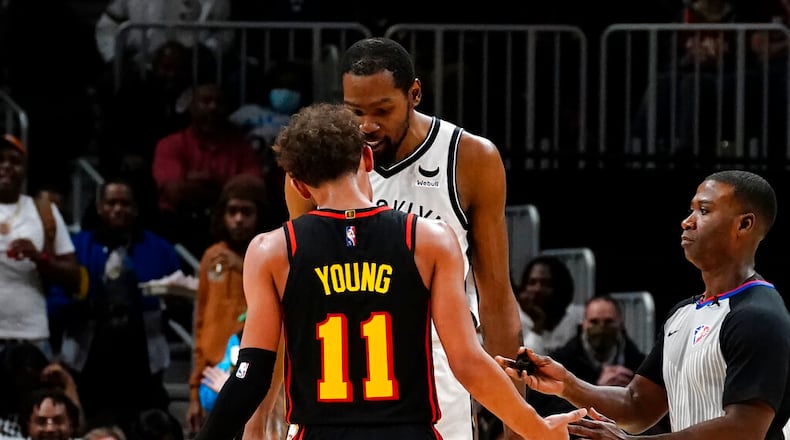 Atlanta Hawks guard Trae Young (11) and Brooklyn Nets forward Kevin Durant exchange words during the second half of an NBA basketball game Friday, Dec. 10, 2021, in Atlanta. (AP Photo/John Bazemore)