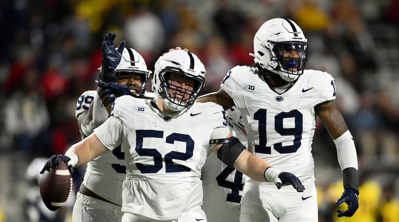 Penn State defensive tackle Jordan van den Berg (52) celebrates with defensive end Jameial Lyons (19) and defensive tackle Coziah Izzard (99) after recovering a fumble by Maryland during the second half of an NCAA college football game, Saturday, Nov. 4, 2023, in College Park, Md. (AP Photo/Nick Wass)