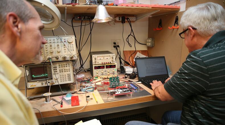 Frank McMahon, left, senior product realization engineer, and Ed Gander, right, principal R&D engineer, work together at Momentum Dynamics in Malvern, Pa. on April 23, 2018. Momentum Dynamics is a Malvern start-up that has developed and deployed a first-of-its-kind wireless charging system for electric buses. (David Maialetti/Philadelphia Inquirer/TNS)